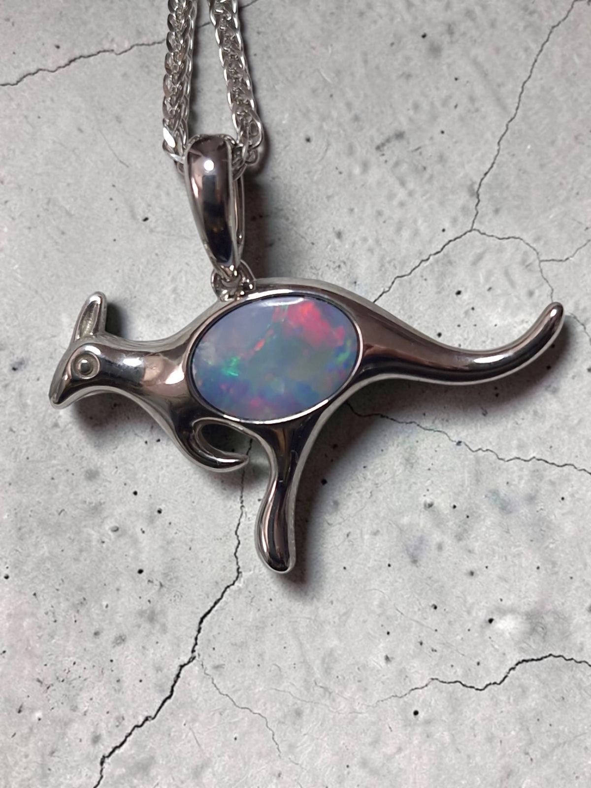 Time & Lustre kangaroo pendant in polished sterling silver with a genuine opal featuring pink and blue colour flashes.