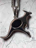 Time & Lustre sterling silver kangaroo pendant necklace featuring a dark opal inlay on a textured stone background.