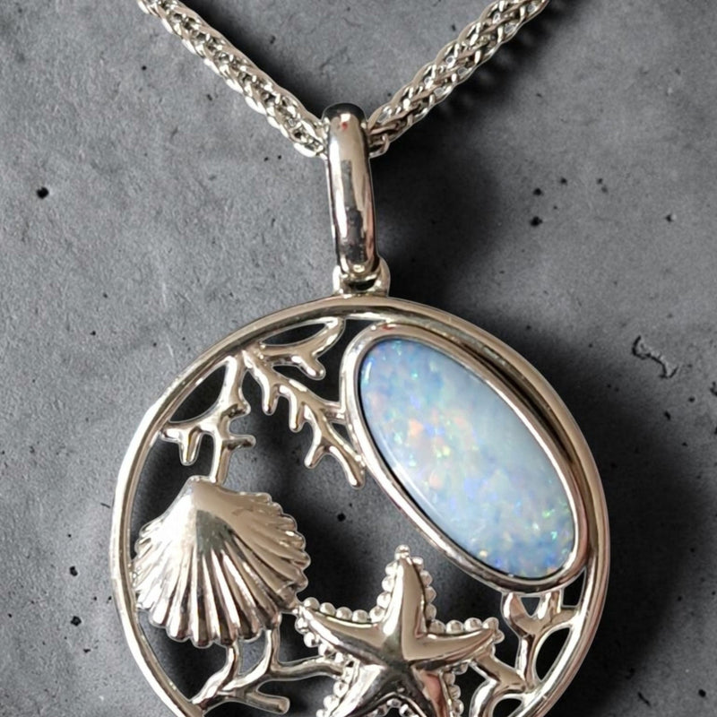 Time & Lustre sterling silver pendant featuring a Lightning Ridge opal doublet with starfish and seashell motifs.