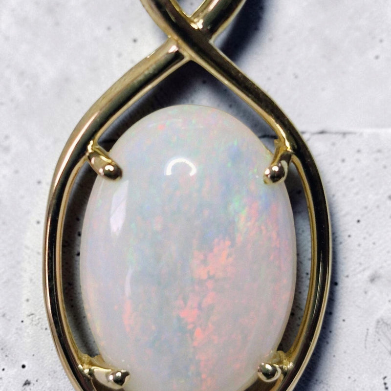Time & Lustre oval cabochon opal pendant in a polished gold four-prong setting with an infinity-inspired bail.