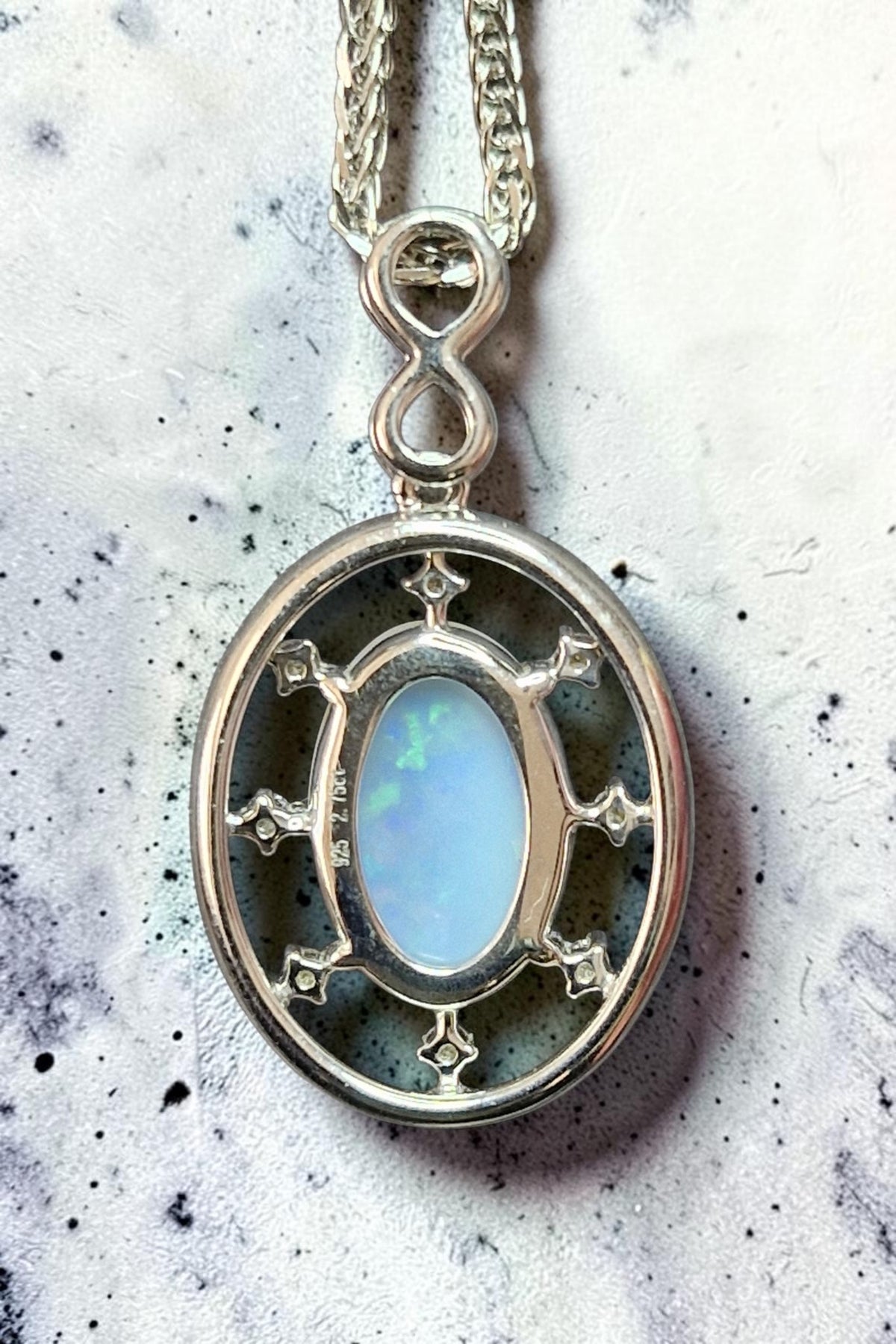 Time & Lustre oval opal pendant necklace in 925 sterling silver with infinity bail and decorative stone accents.