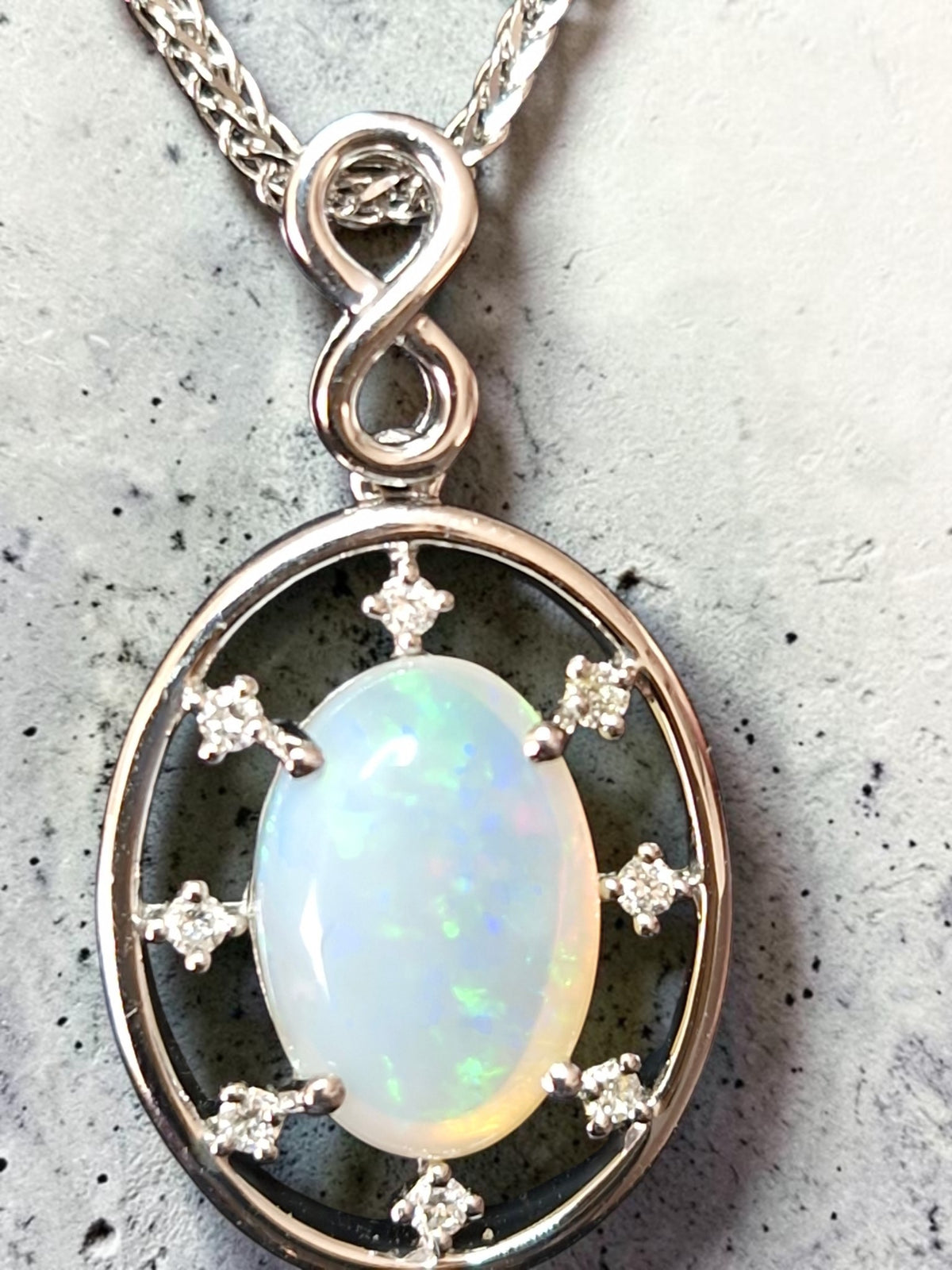 Time & Lustre oval opal pendant in 925 sterling silver with accent stones and an infinity bail on a silver chain.