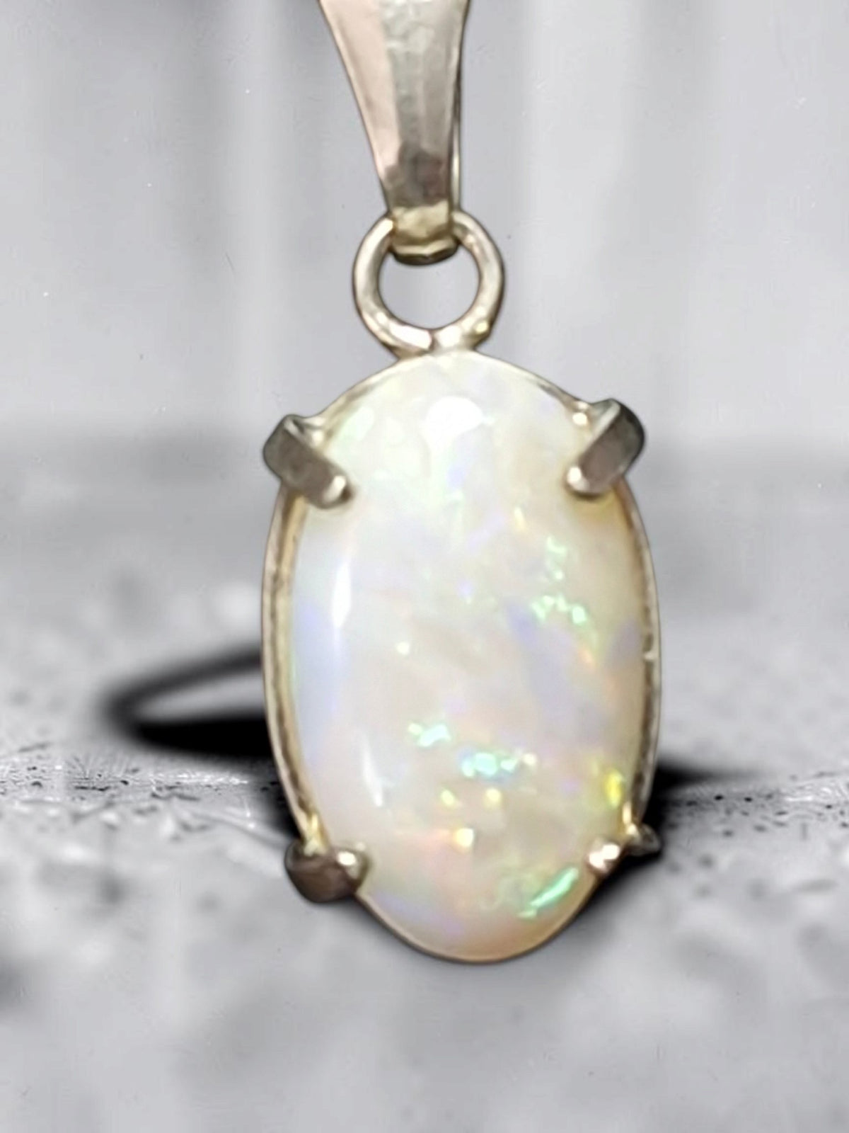 Time & Lustre oval opal pendant in 925 sterling silver with a four-prong setting showing iridescent colour flashes.