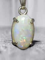 Time & Lustre oval opal pendant in 925 sterling silver with a four-prong setting showing iridescent colour flashes.