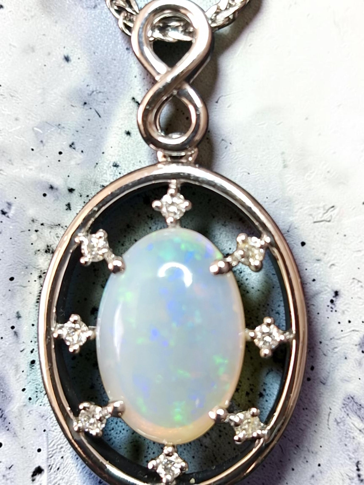 Time & Lustre oval opal pendant in 925 sterling silver with sparkling accent stones and an infinity-style bail.