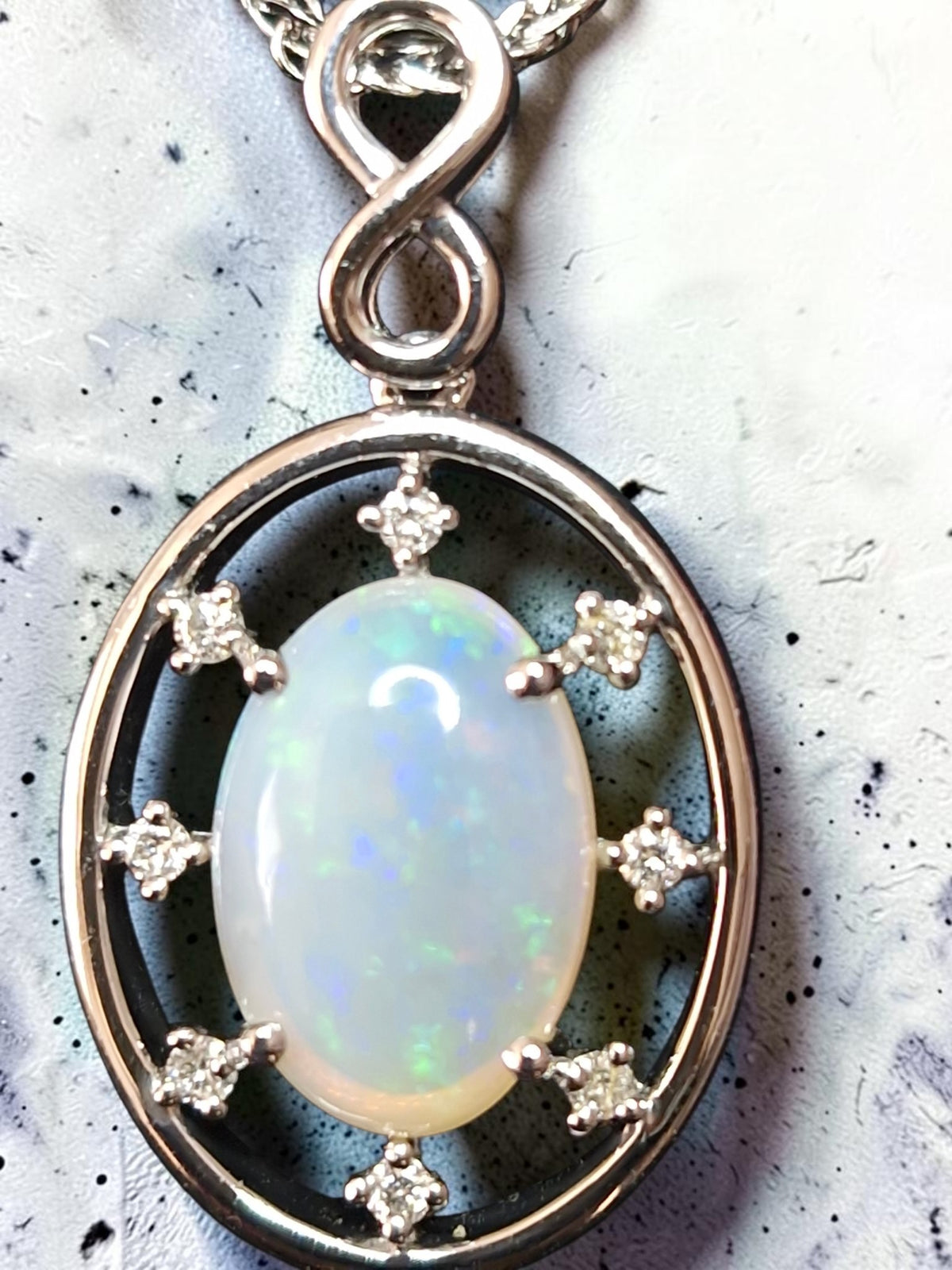 Time & Lustre oval opal pendant in 925 sterling silver with sparkling accent stones and an infinity-style bail.