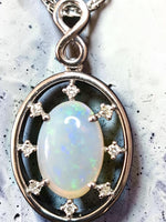 Time & Lustre oval opal pendant in 925 sterling silver with sparkling accent stones and an infinity-style bail.