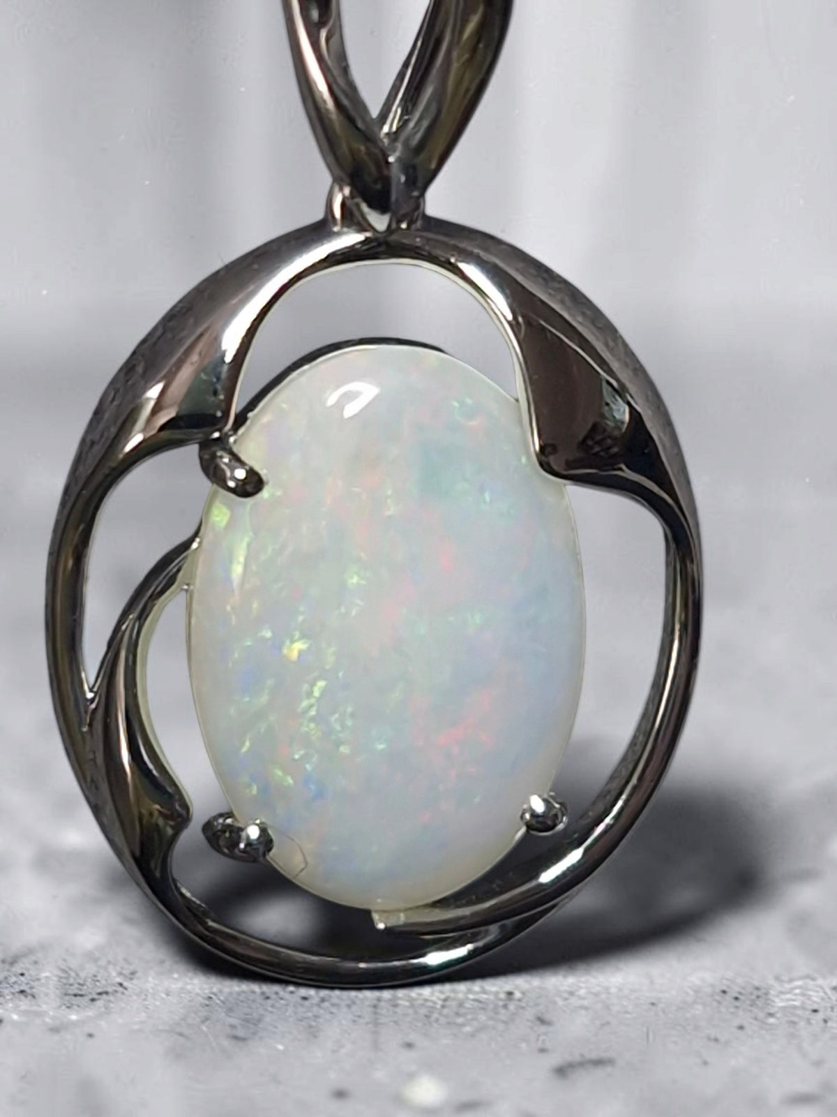 Time & Lustre oval opal pendant featuring a luminous gemstone with iridescent flashes in a polished silver-tone frame.