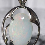 Time & Lustre oval opal pendant featuring an iridescent gemstone in a polished silver-toned organic frame.