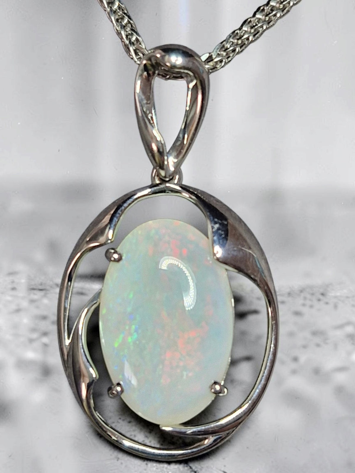 Time & Lustre oval opal pendant featuring an iridescent gemstone in a polished silver-toned organic frame.