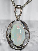 Time & Lustre oval opal pendant featuring an iridescent gemstone in a polished silver-toned organic frame.