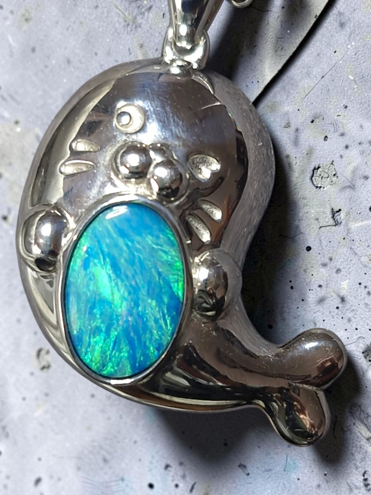 Time & Lustre sterling silver seal pendant featuring a vibrant blue and green iridescent opal inlay.