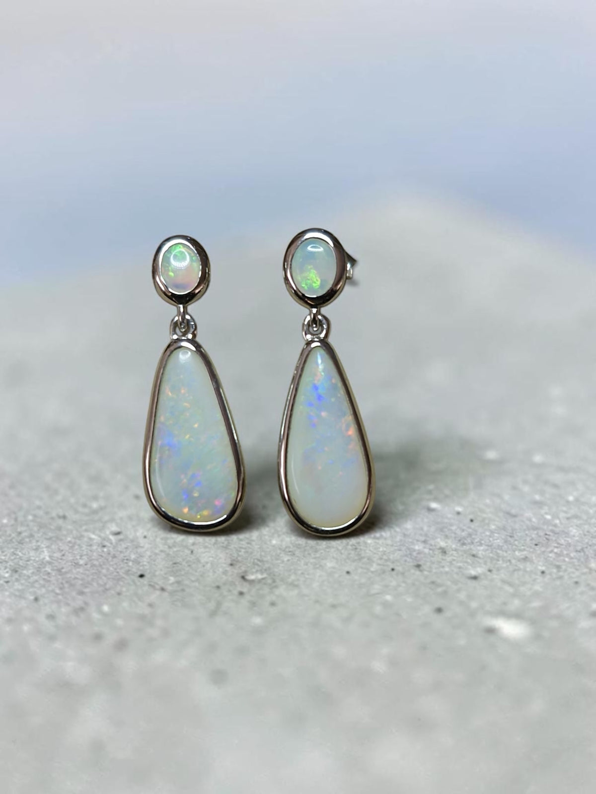 Time & Lustre teardrop opal drop earrings in polished sterling silver with oval studs and iridescent gemstone flashes.