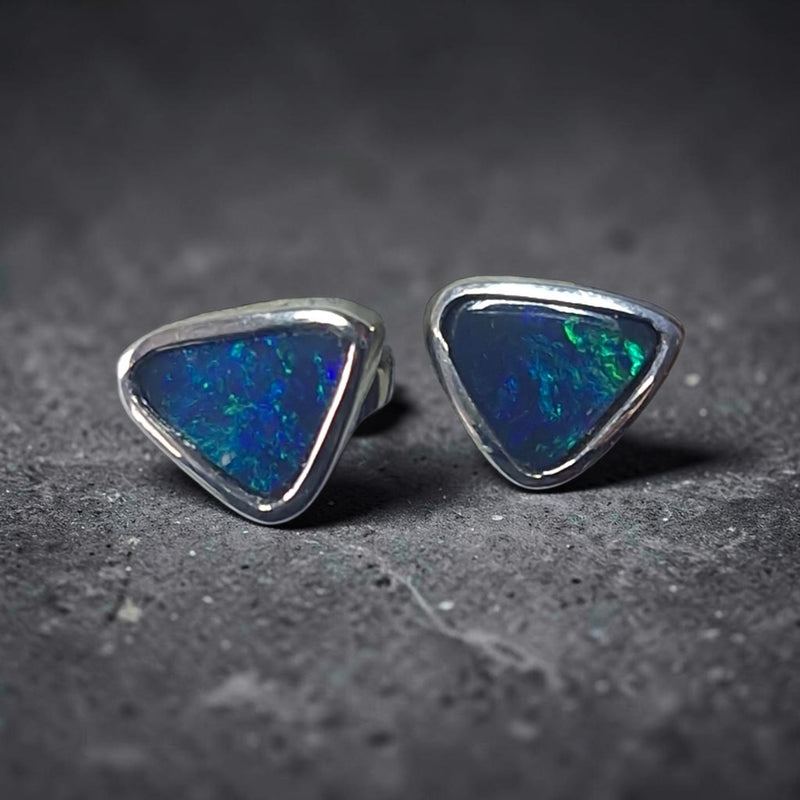 Time & Lustre triangle-cut black opal stud earrings in sterling silver featuring vibrant blue and green colour flashes.